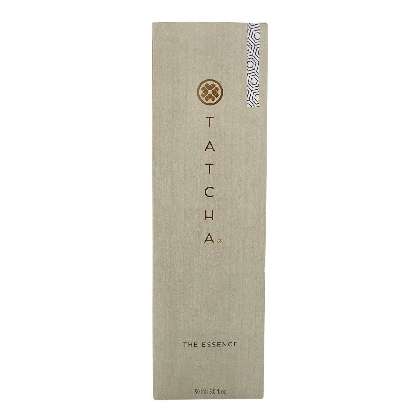 A tall, slim bottle of Tatcha The Essence Plumping Skin Softener with a beige label and a small decorative pattern on the lower right corner.