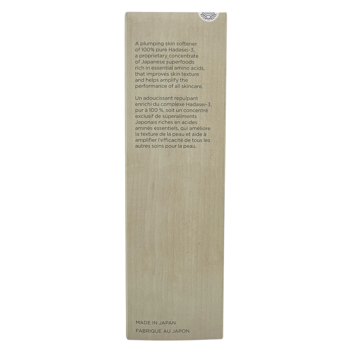 A tall, slim bottle of Tatcha The Essence Plumping Skin Softener with a beige label and a small decorative pattern on the lower right corner.