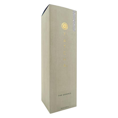 A tall, slim bottle of Tatcha The Essence Plumping Skin Softener with a beige label and a small decorative pattern on the lower right corner.