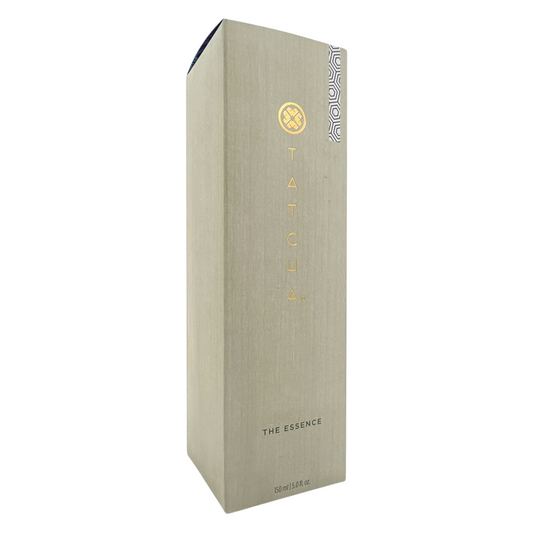 A tall, slim bottle of Tatcha The Essence Plumping Skin Softener with a beige label and a small decorative pattern on the lower right corner.