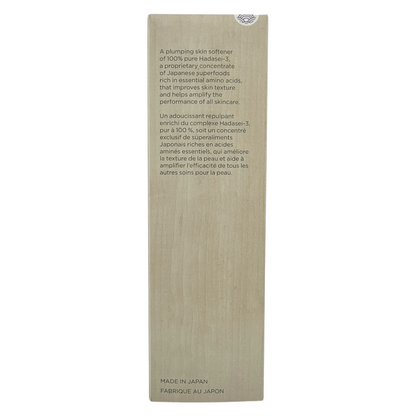 A tall, slim bottle of Tatcha The Essence Plumping Skin Softener with a beige label and a small decorative pattern on the lower right corner.
